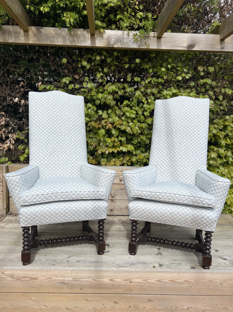 Elegant vintage armchairs featuring a light blue patterned upholstery and turned wooden legs, perfect for adding a classic touch to any space.