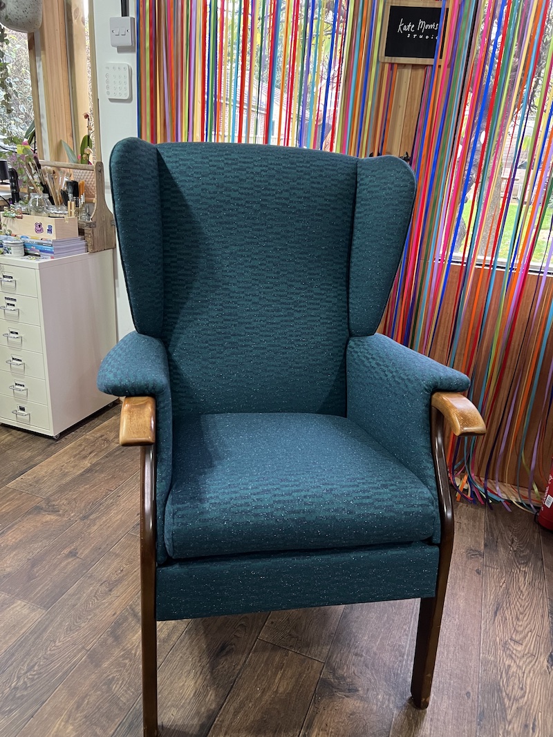 Stylish Wingback Chair in teal upholstery, featuring comfortable armrests and a classic design, perfect for any living space.