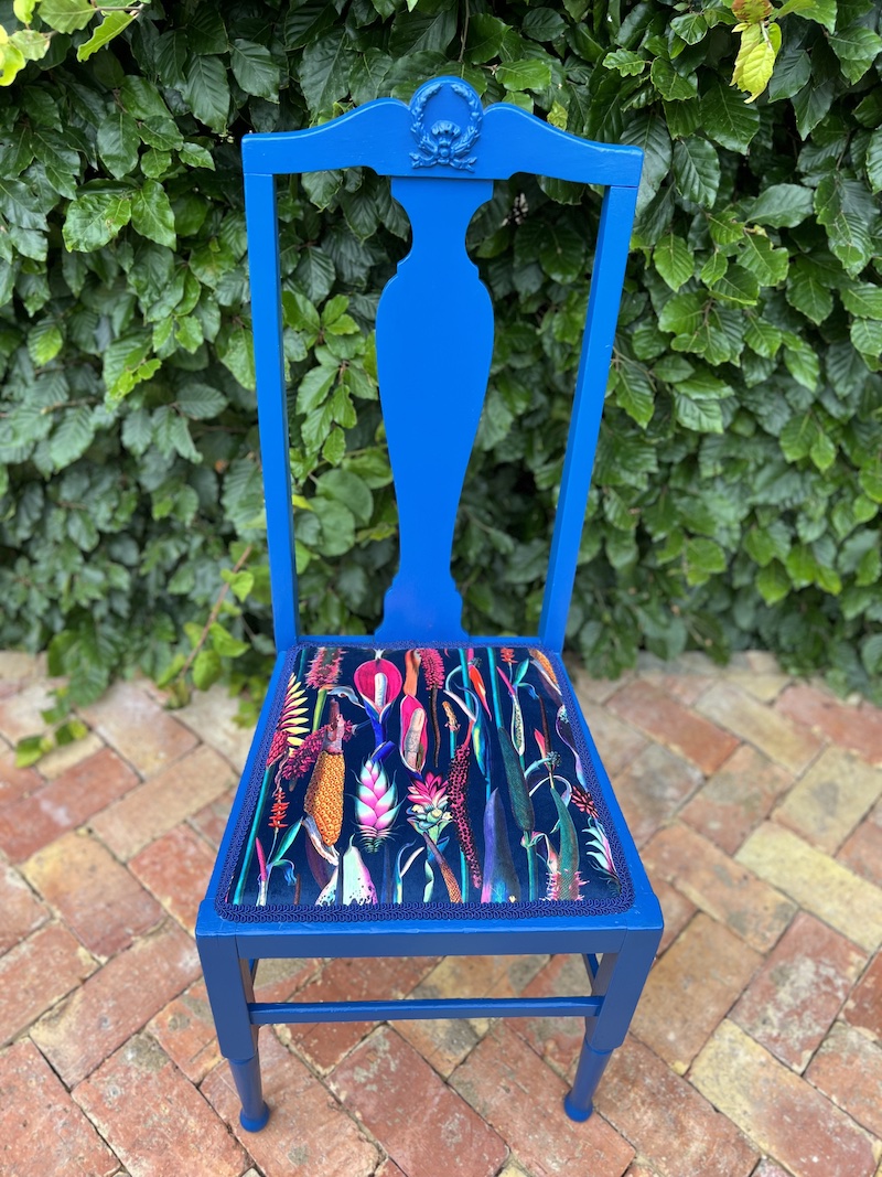Vibrant blue botanical chair featuring a colorful floral-patterned seat, perfect for adding a pop of color to any space.