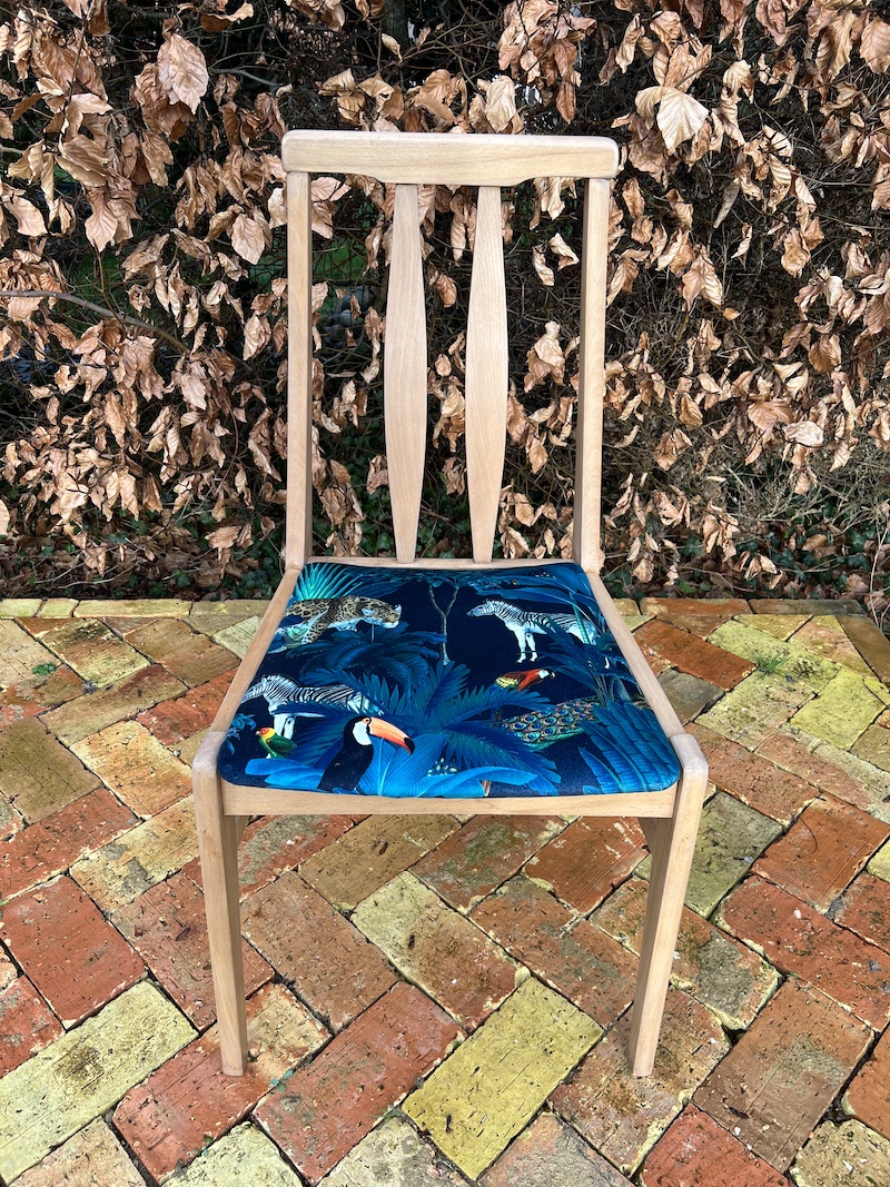 Set of 4 restored dining chairs featuring a vibrant, wildlife-themed seat design and a sleek wooden frame.