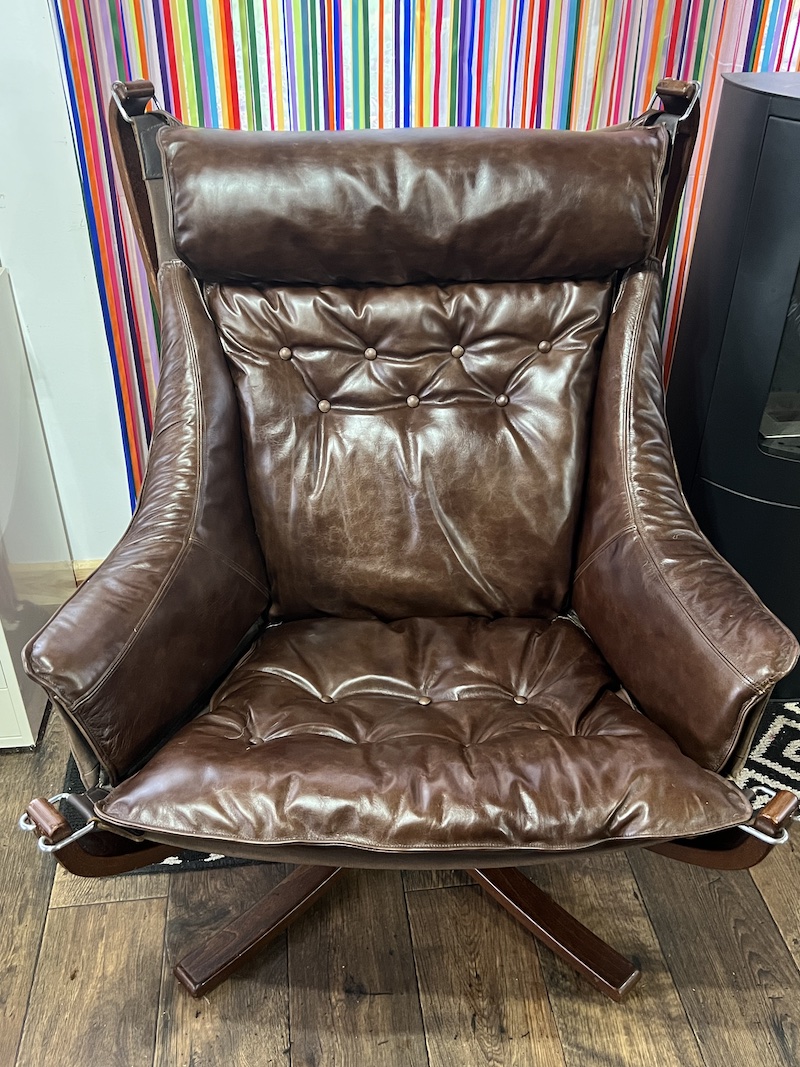 Experience comfort with the FALCON CHAIR, featuring plush brown leather upholstery and a stylish, modern design.