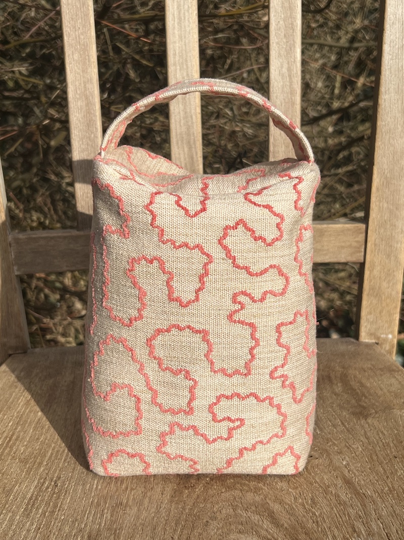 Stylish door weight in warm pinks, featuring a textured design and convenient handle for easy placement.