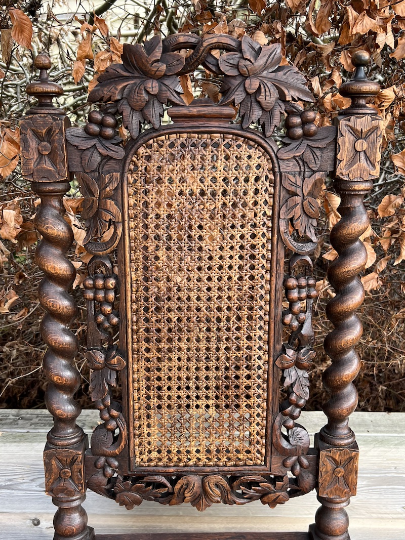 Exquisitely crafted Jacobean carved cane chair featuring intricate floral motifs and a sturdy, elegant design.