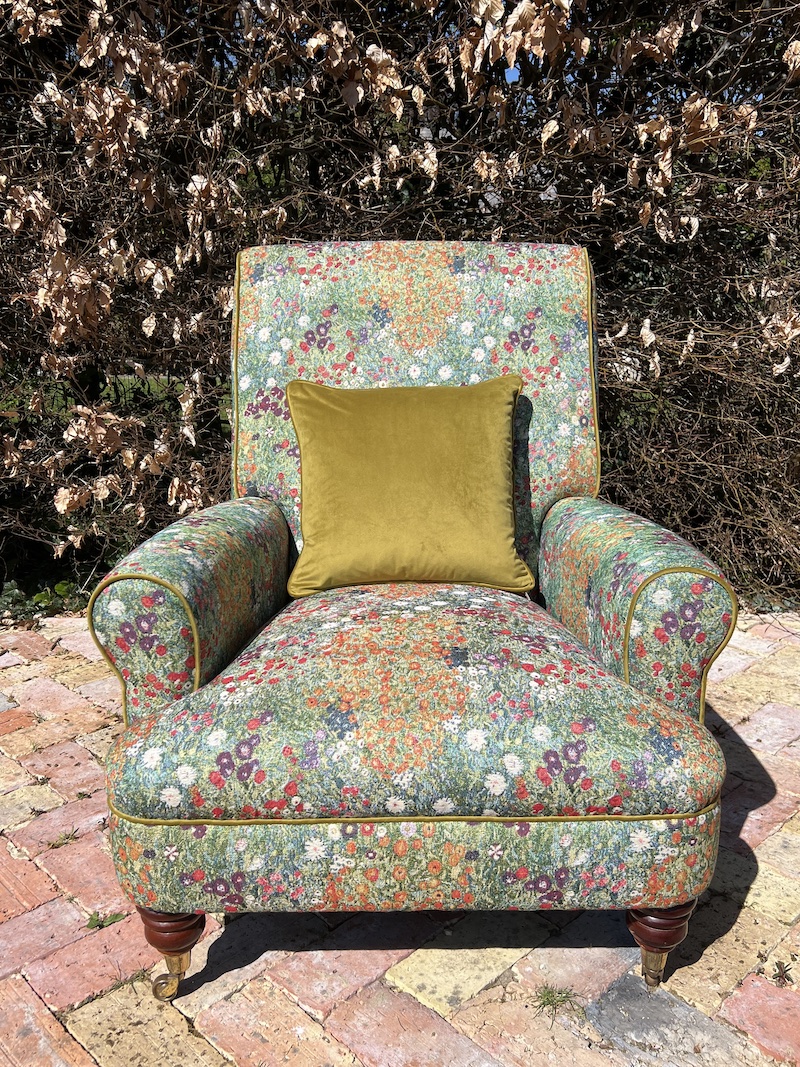 Elevate your space with the Floral Armchair, featuring vibrant botanical upholstery and a complementary green accent pillow.