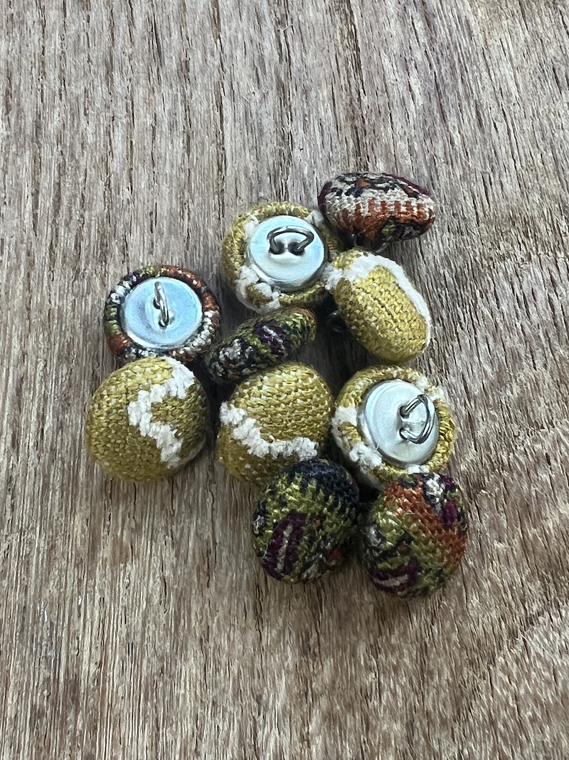 A vibrant set of handmade buttons in autumn hues, perfect for adding a unique touch to your projects.
