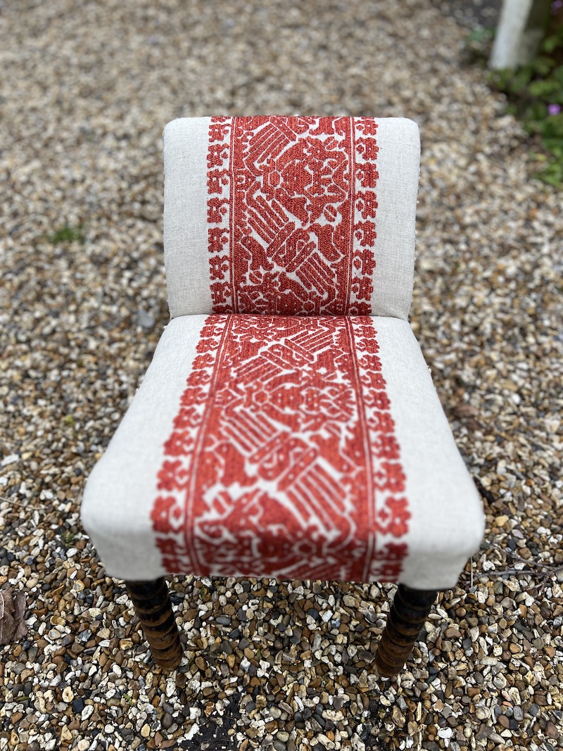 Stylish GOUT STOOL featuring intricate red embroidery on a neutral fabric, perfect for adding a unique touch to any space.