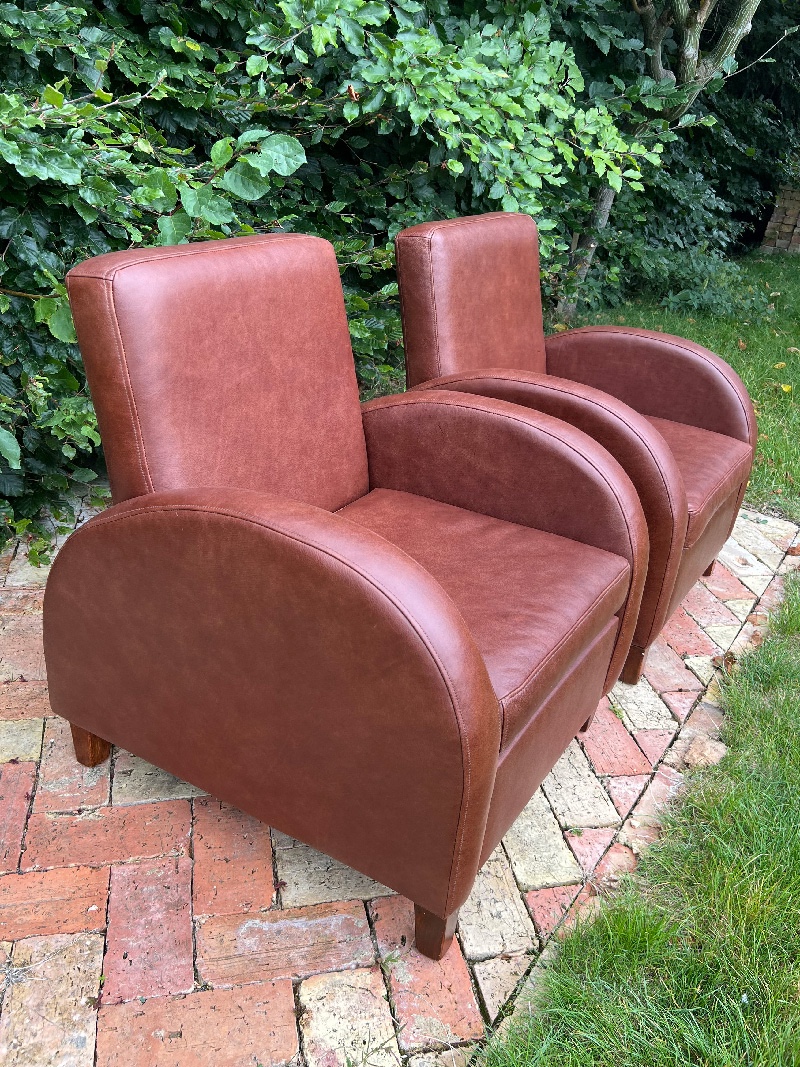 Stylish leather club chairs featuring a sleek design, perfect for enhancing any living space.