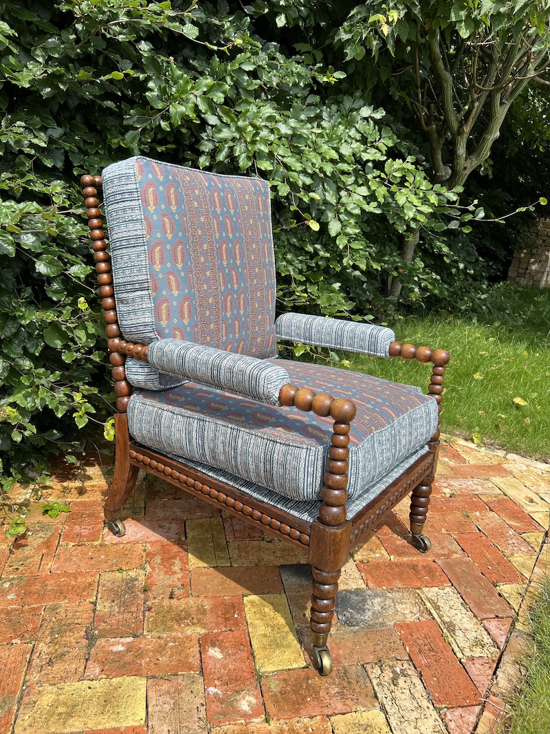 The BOBBIN CHAIR features a stylish design with patterned upholstery and wooden accents, perfect for adding charm to any space.
